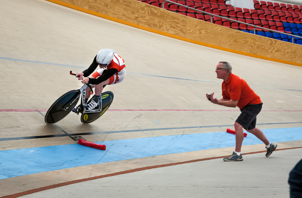 Eric Jonhstone of Calgary rides to a silver medal in the men's individual pursuit as coach Rob Good provides encouragement. Photo credit: Ivan Rupes