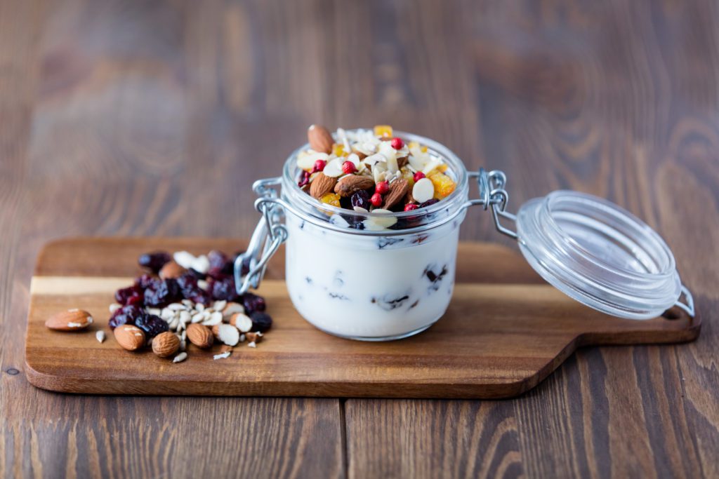 Homemade yogurt or sour cream with nuts and raisins in a glass