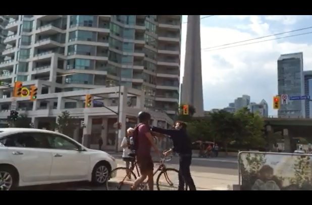 In a video published by Metro News, a pedestrian is seen punching a cyclist during an altercation on the Queen's Quay bike lane. 