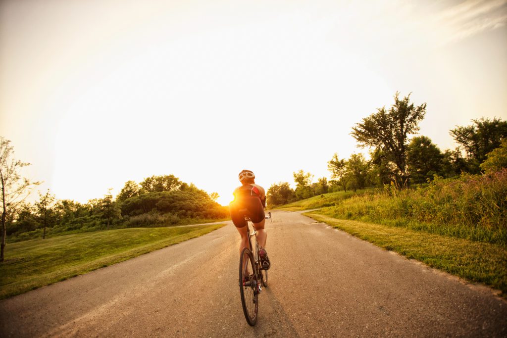 Woman riding into the sunset on her bicycle