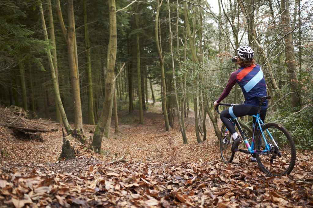 Cross-country cyclist drinking as he cycles in a forest