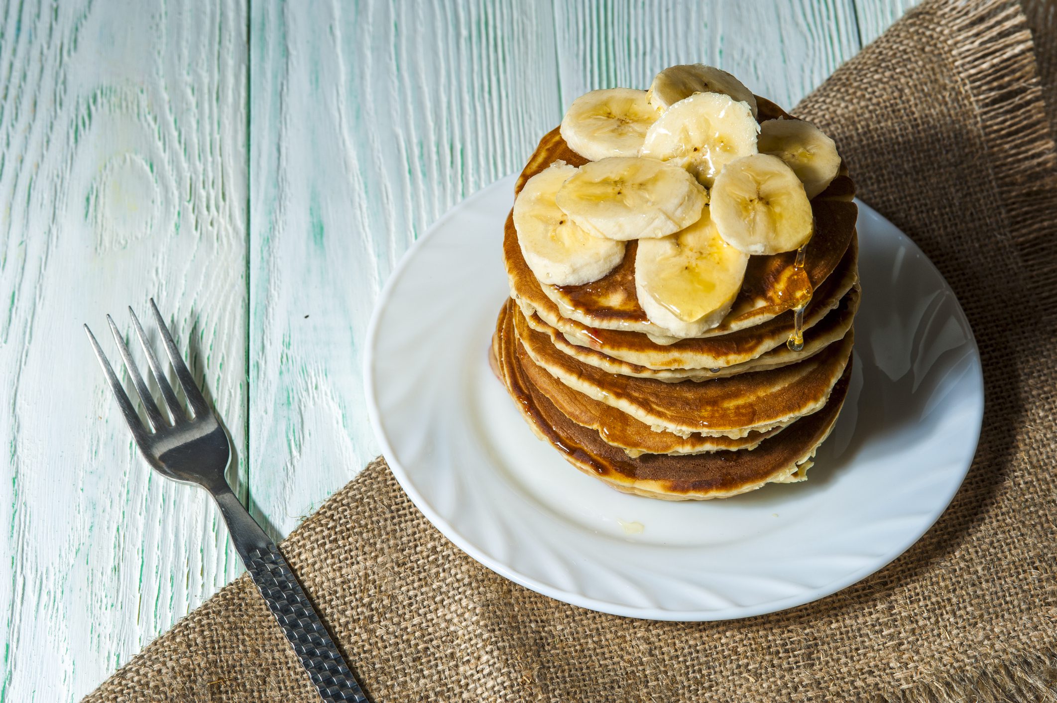 pancakes with banana slices on white plate