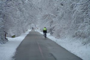 Bicyclist on trail on snowy day.
