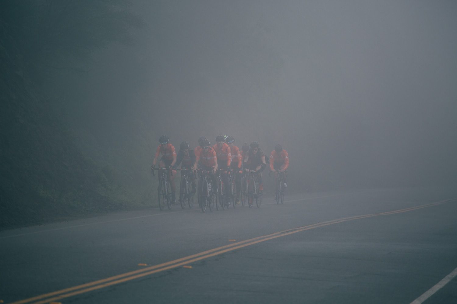 The team rides through the damp fog