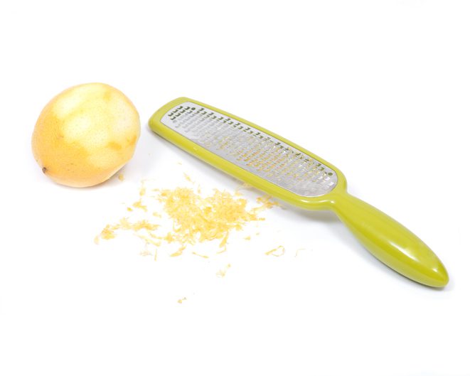 Stainless steel grate zester with lemon isolated on white background