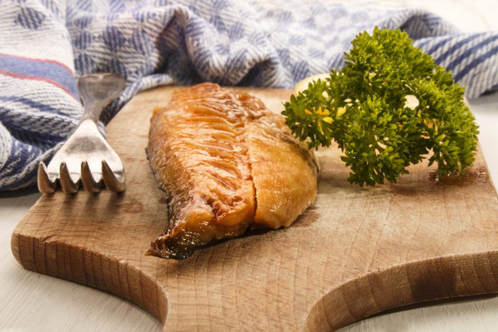 smoked mackerel from scotland with parsley on a wooden board