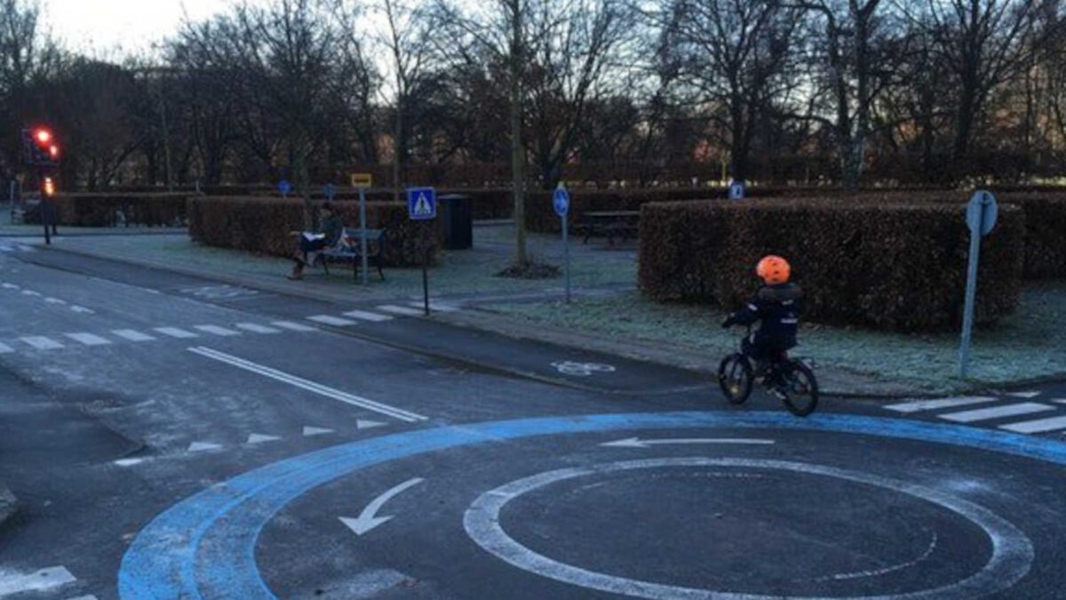 A danish child rides their bike in a playgtound