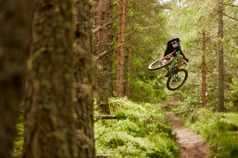 Jackson Goldstone jumps a mountain bike on a trail in Scotland 