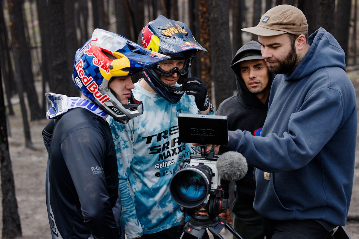 Riders and videographers look at a camera screen