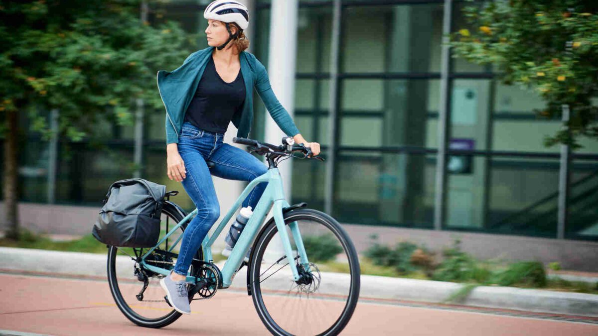 Woman riding new Trek FX+ 2 e-bike in a city