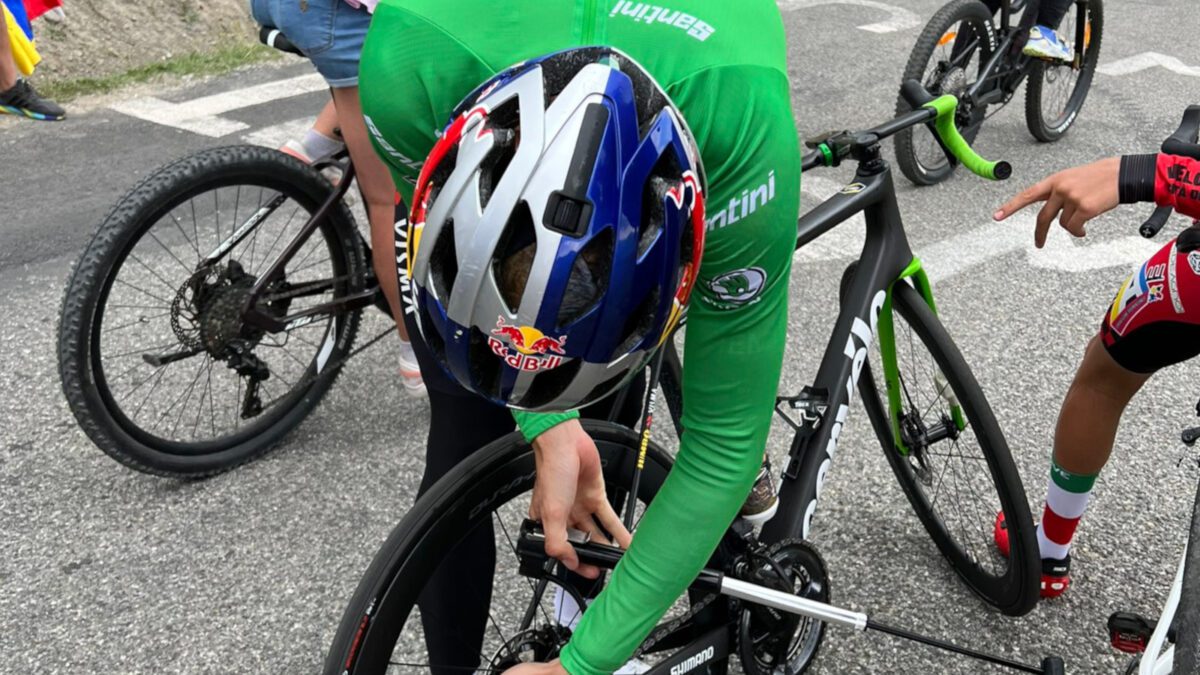Wout van Aert, in his green jersey, pumps his tire