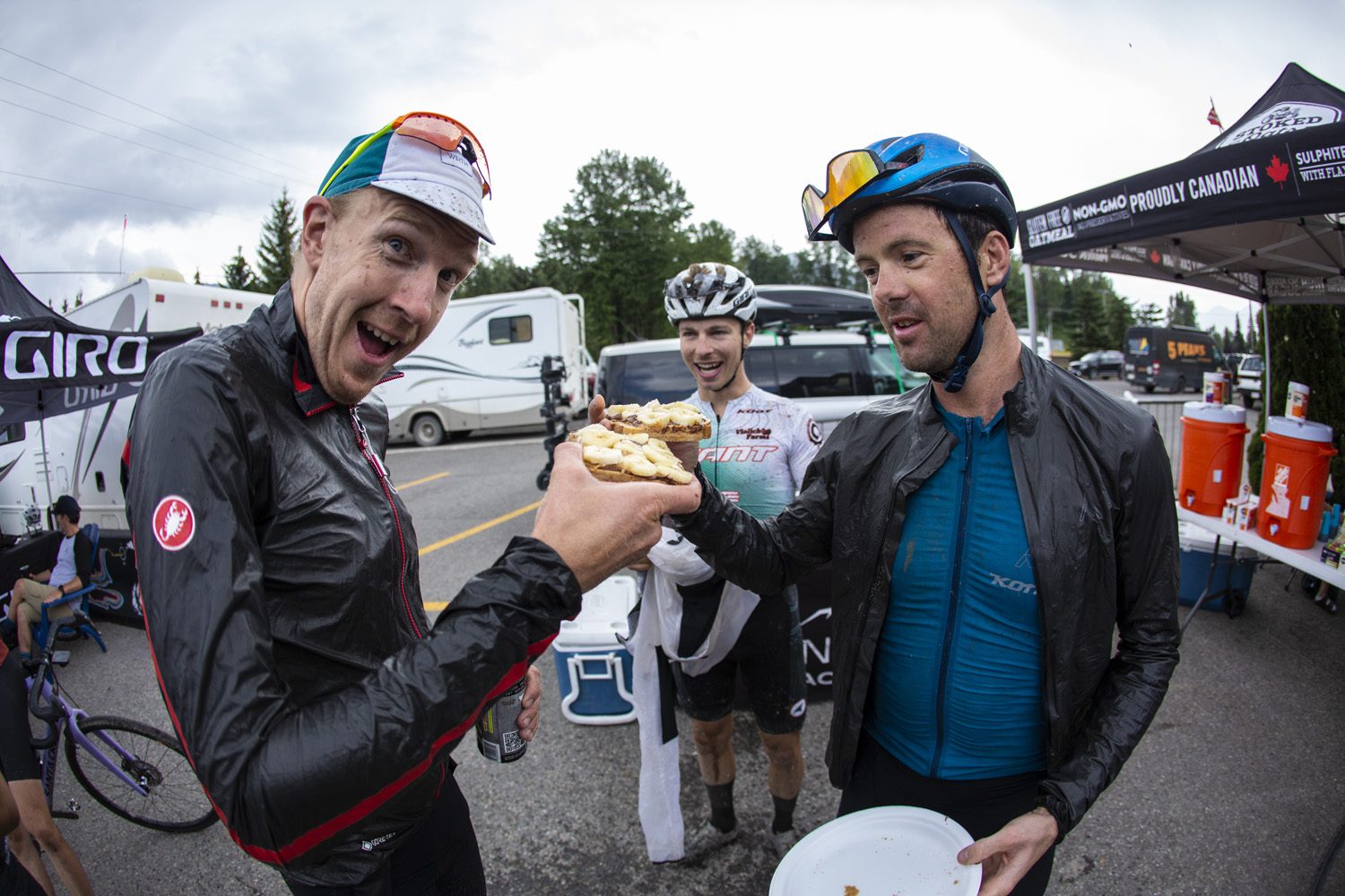 Rob Britton and Cory Wallace cheers with sandwiches at TransRockies Gravel Royale
