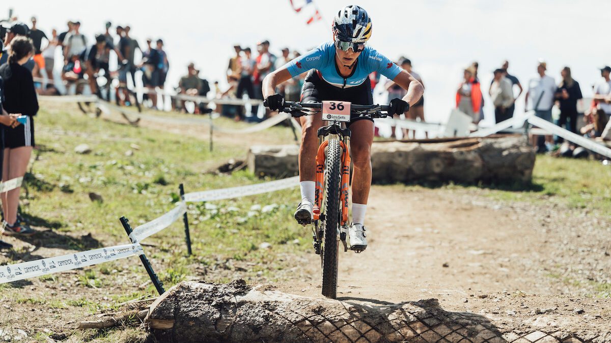 Emily Batty rides over a log at 2022 mountain bike world championship XCO