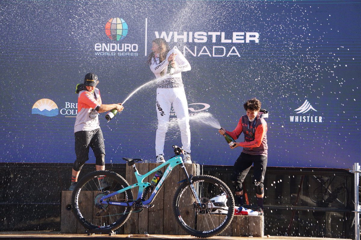 Riders spray champagne on the podium in Whistle r