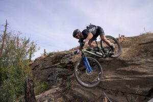 Peter Disera rolls over a steep rock at 2022 BC Bike Race