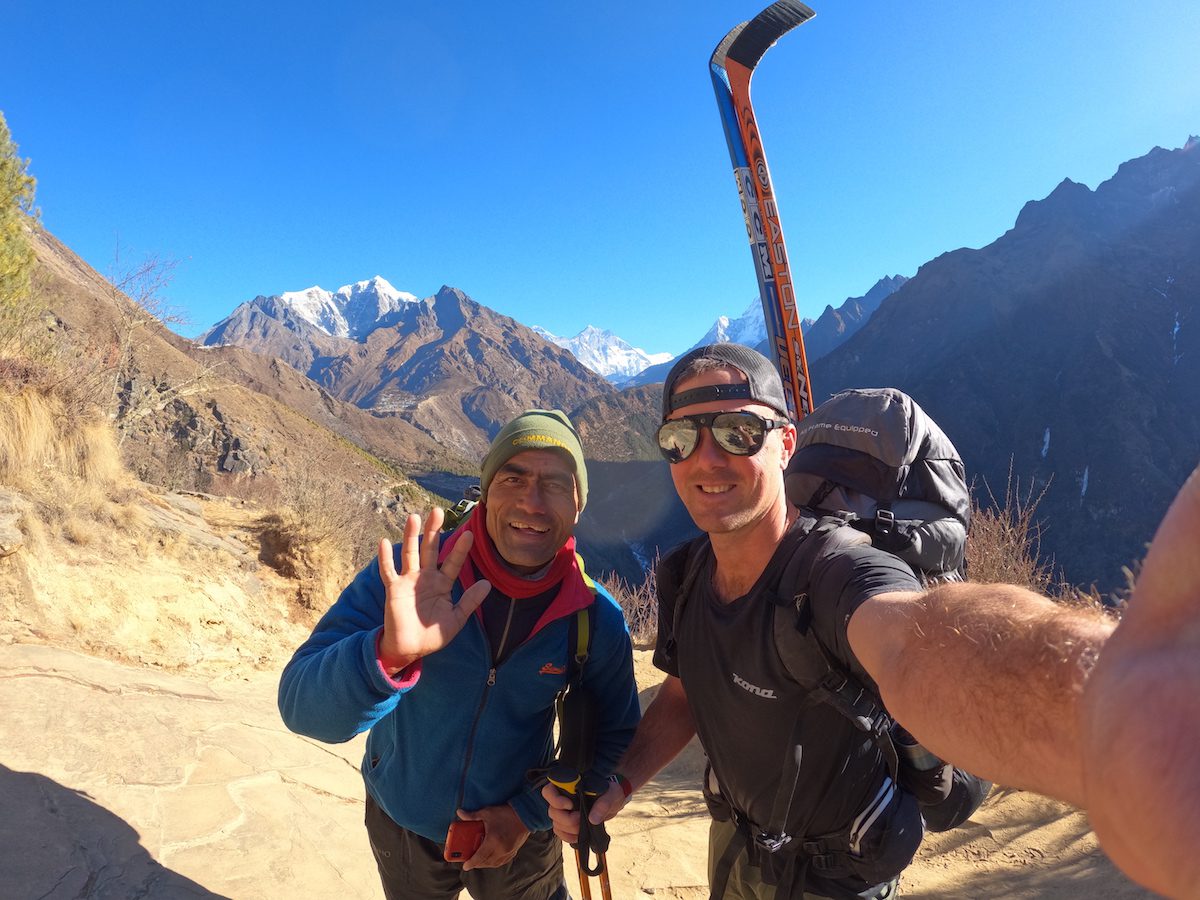 Cory Wallace takes a selfie with a local on his way to himalayan hockey 