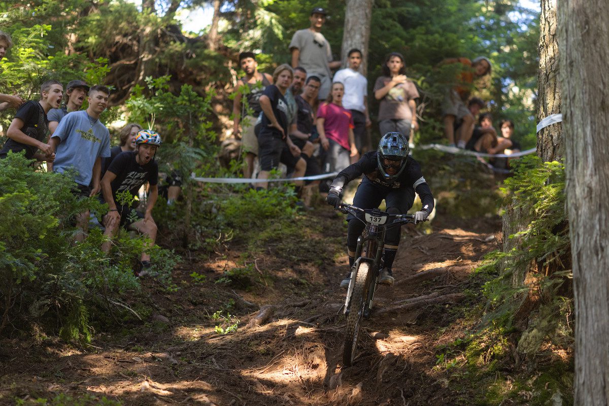 Miranda Miller races by a crowd during the 2022 Canadian Open Enduro during Crankworx 