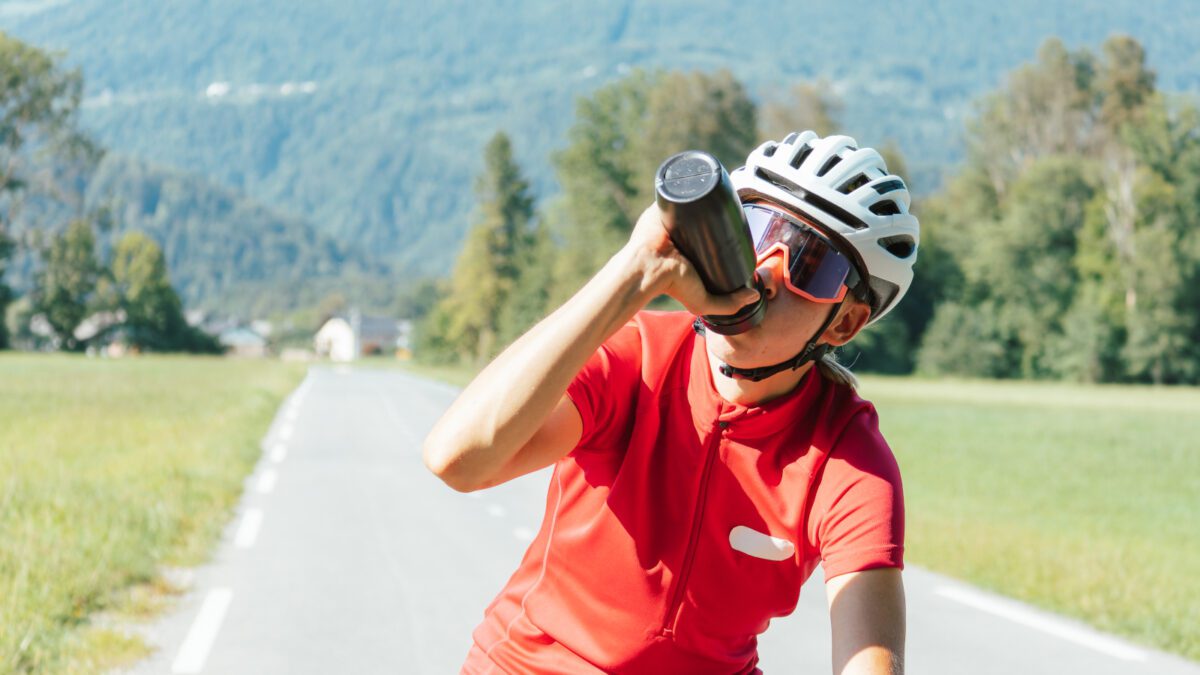 Female road cyclist keeping hydrated during a ride